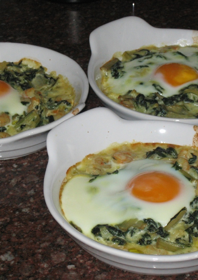 Una foto de Huevos al plato con gambas y acelgas
