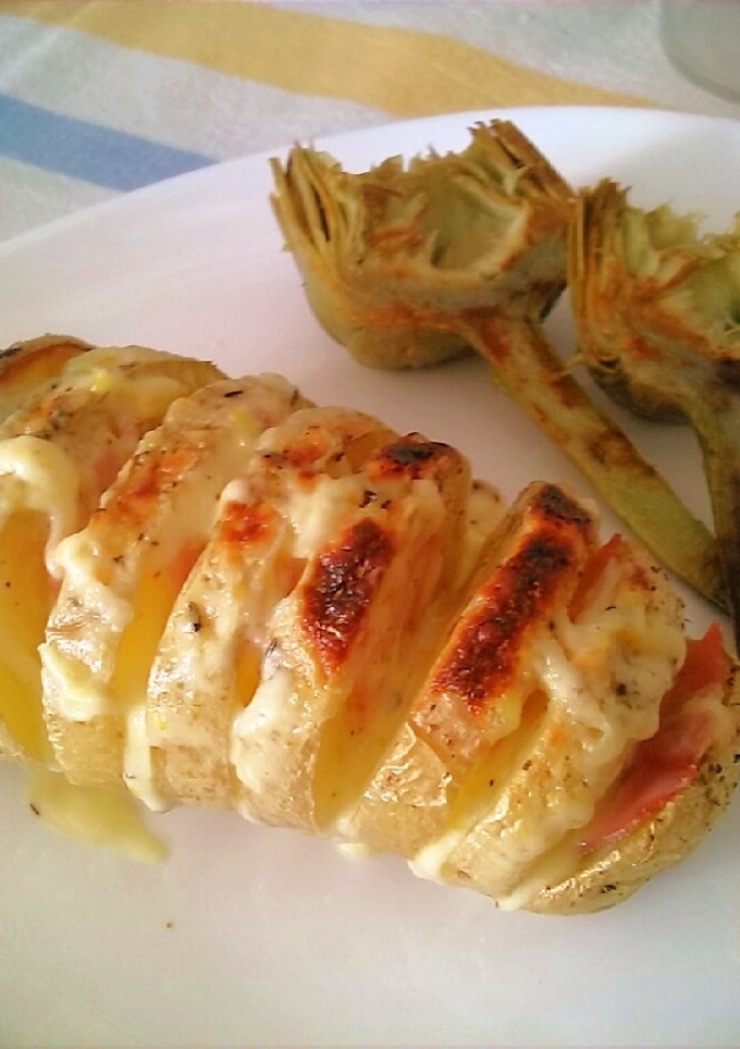 Una foto de Patatas al horno en libro con salsa Cheddar