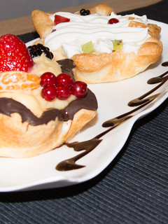 Una foto de Tartaletas de hojaldre, fruta en base de crema pastelera y nata montada