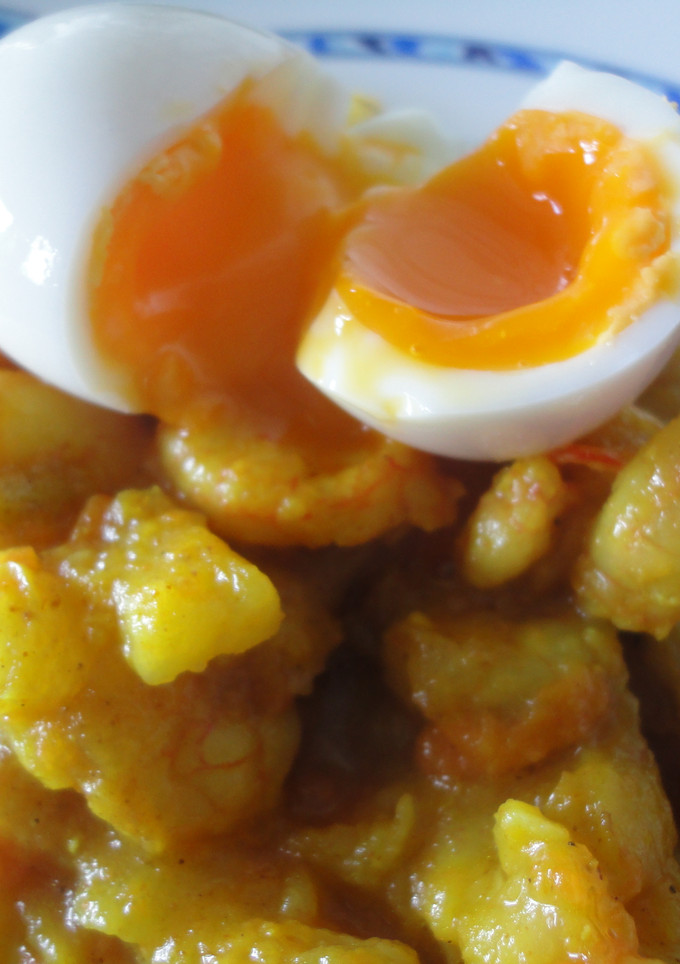 Una foto de gambas al curry acompañadas de huevos pasados por agua