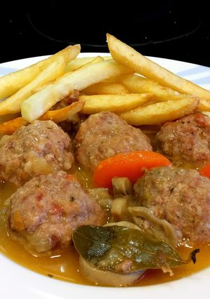 A picture of Homemade Meatballs in Sauce with French Fries.