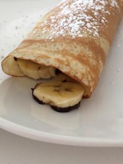 Una foto de Crepes rellenos de plátanos con chocolate caliente