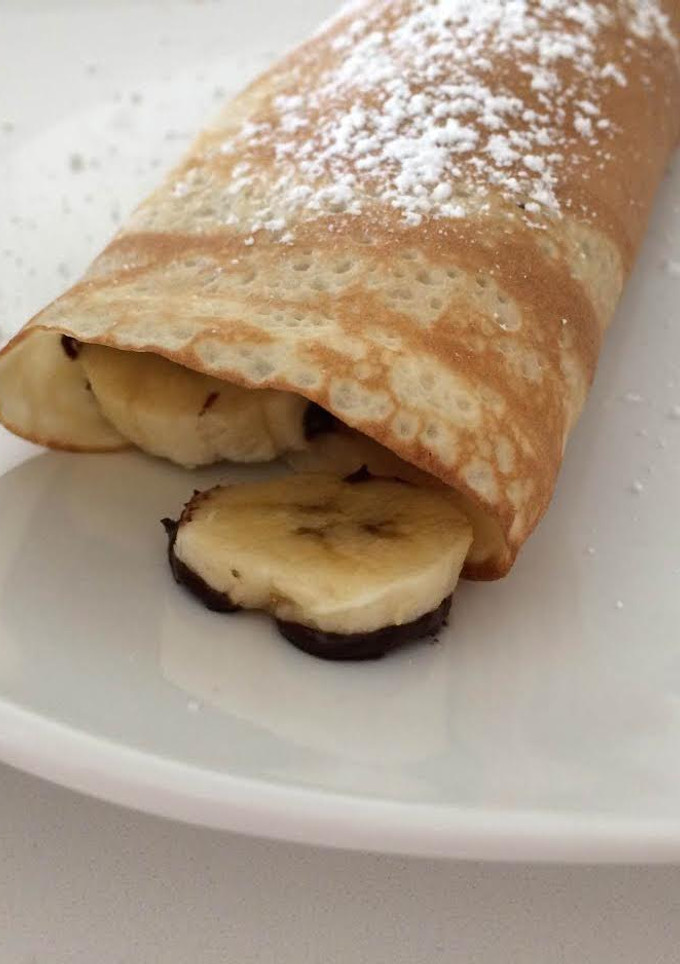 Una foto de Crepes rellenos de plátanos con chocolate caliente