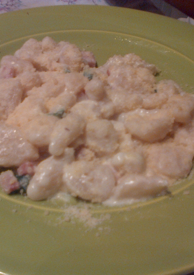 Una foto de Ñoquis de ricota y queso con salsa