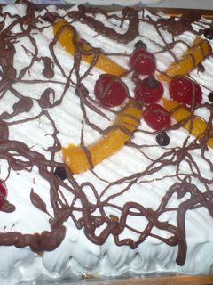Una foto de Torta con merengue, duraznos, chocolate y cerezas