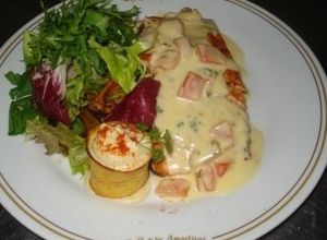 Una foto de Salmón la duglere con escarola fina sobre vegetales salteados y hummus