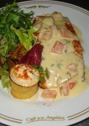 Una foto de Salmón la duglere con escarola fina sobre vegetales salteados y hummus