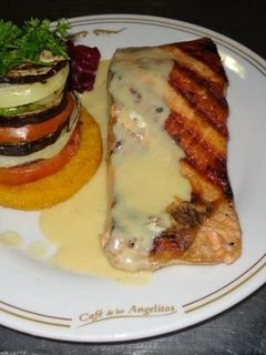 Una foto de Salmón al vino blanco con vegetales grillados sobre polenta frita