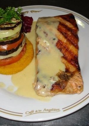 Una foto de Salmón al vino blanco con vegetales grillados sobre polenta frita