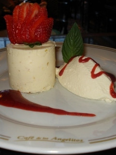 Una foto de Cheese cake de naranja con crema batida y salsa de frutilla