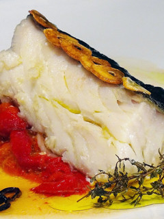 Una foto de Bacalao confitado sobre pimientos asados