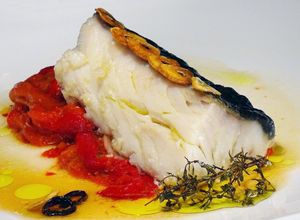Una foto de Bacalao confitado sobre pimientos asados