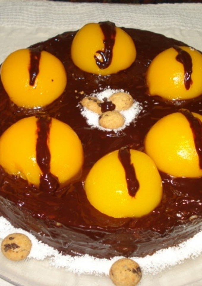 Una foto de Torta de bizcochuelo con crema inglesa, chocolate y melocotones
