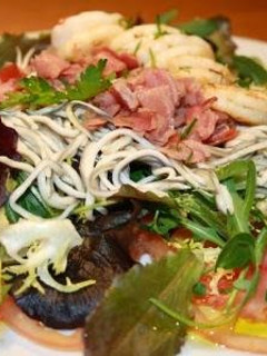 Una foto de Ensalada templada de gulas, langostinos y jamón con lechugas variadas
