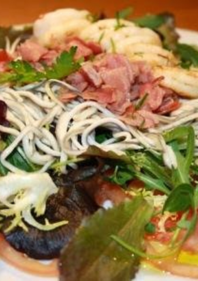 Una foto de Ensalada templada de gulas, langostinos y jamón con lechugas variadas
