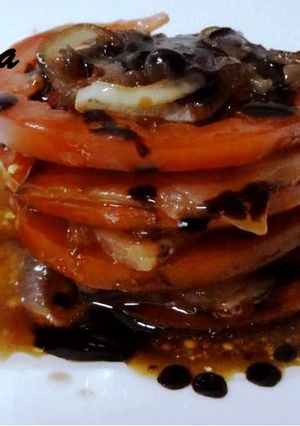 Una foto de Tapa de salmón con tomate y cebolla caramelizada