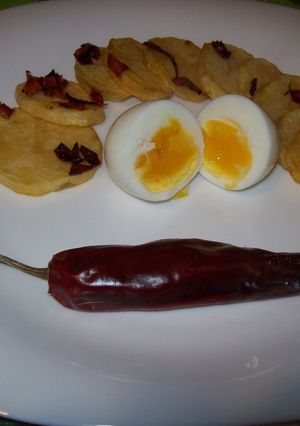 Una foto de Huevos mollet con papas picantes