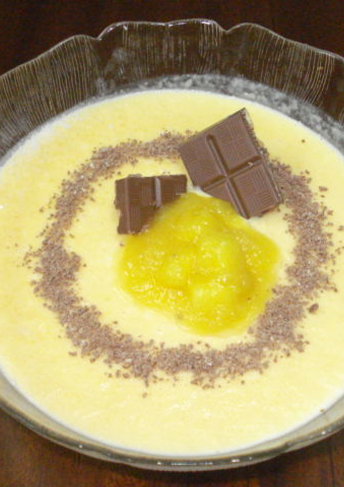 Una foto de Crema helada de melocotones con salsa de piña y chocolate con almendras