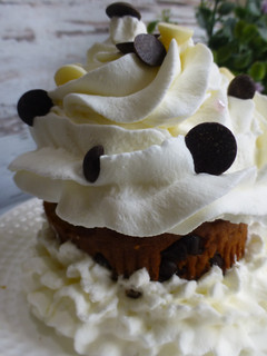 Una foto de Cupcake relleno de trufa, cubierto de nata y pepitas de chocolate