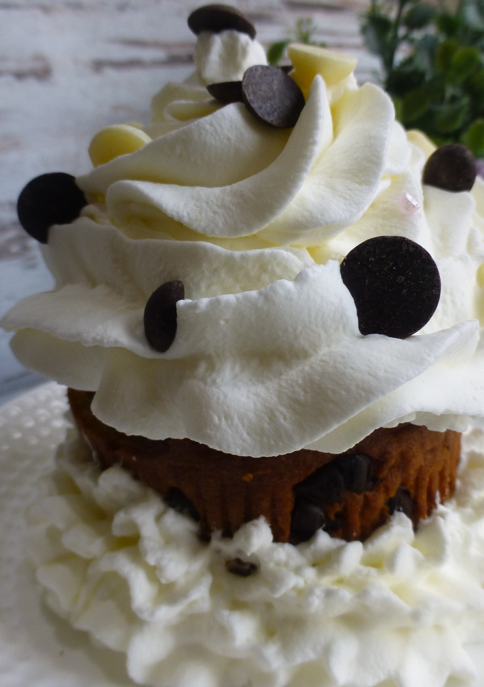 Una foto de Cupcake relleno de trufa, cubierto de nata y pepitas de chocolate