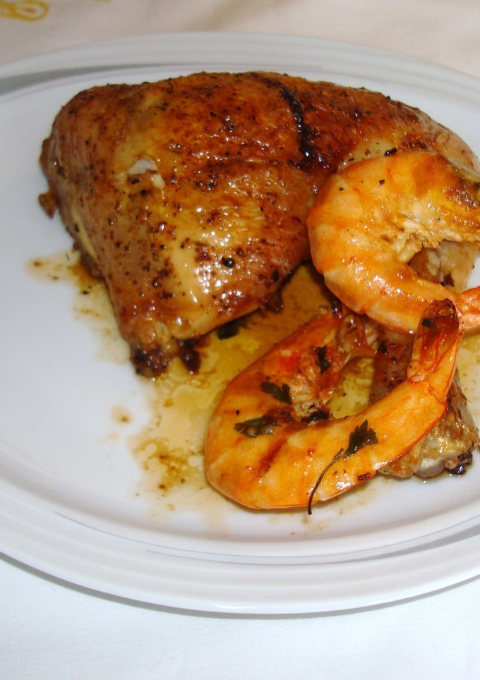 Una foto de Pollo al horno con langostinos al cava