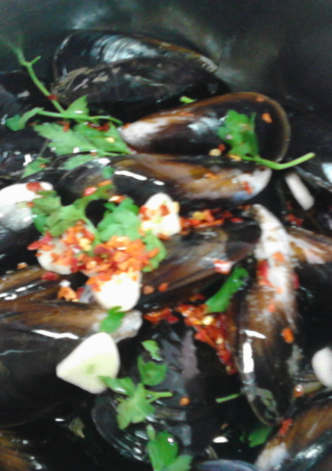 Una foto de mejillones con copos de chile