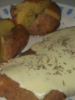 Una foto de Milanesas con queso cremoso y papas rústicas