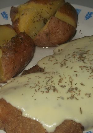 Una foto de Milanesas con queso cremoso y papas rústicas