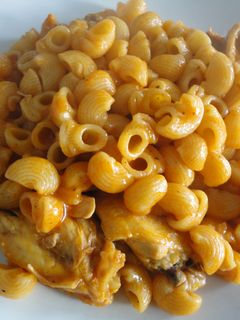 Una foto de macarrones con pollo y tomate.