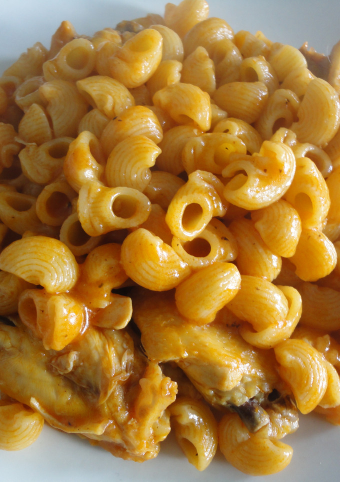 Una foto de macarrones con pollo y tomate.