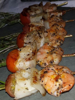 Una foto de Brochetas de lubina con romero y langostinos con azafrán