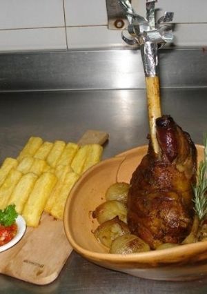 Una foto de Gigot braseado con cebollas, hinojos y papas bastón