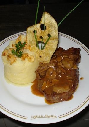 Una foto de Bifes de chorizo a la zíngara con puré de papas y chips de ajo