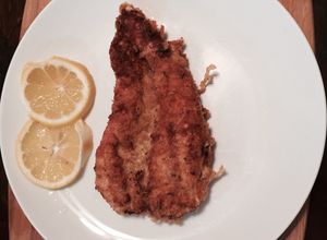 Una foto de Pechuga de pollo cubierta con parmesano y panko