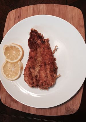 Una foto de Pechuga de pollo cubierta con parmesano y panko