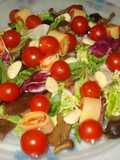 Ensalada variada con pinchos de tomate y queso.