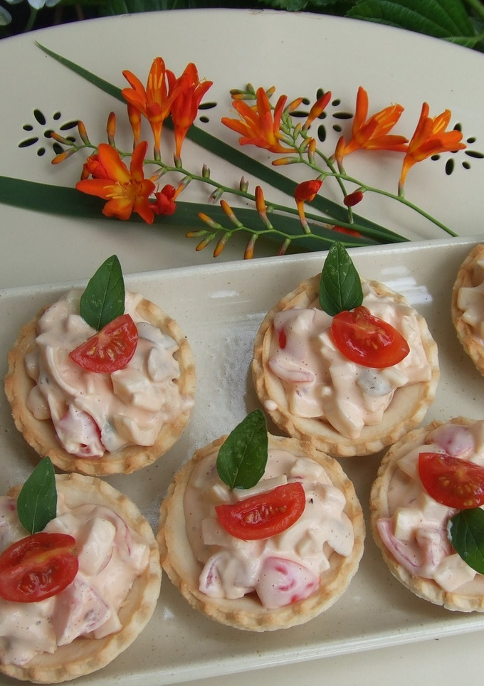 Una foto de Cestitos de salmón con palmitos y tomatitos 