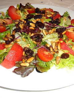 Una foto de Ensalada con vinagreta de uvas pasas y piñones