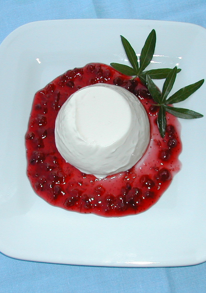 Una foto de Flan de queso con salsa de maracuyá y mango