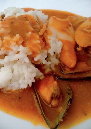 Una foto de Delicias del mar en salsa con guarnición de arroz