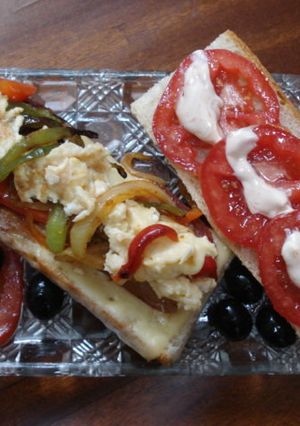 Una foto de Bocadillo con bacon, queso, huevo, verduras, tomate y olivas