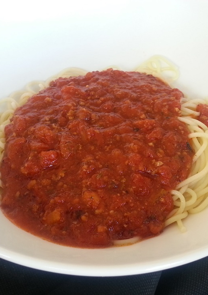 Una foto de Espaguetis con tomate, albahaca fresca y ajo