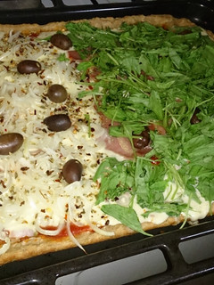 Una foto de Pizza integral de cebolla, rúcula y jamón crudo