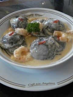 Una foto de Sorrentino negros con mousseline y crema o salsa de langostinos