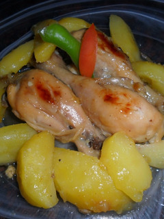 Una foto de Muslitos de pollo y patatas a la naranja