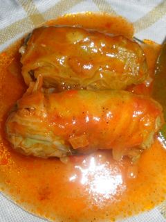 Una foto de Niños envueltos en hojas de col con salsa de tomate