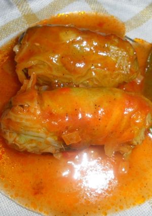 Una foto de Niños envueltos en hojas de col con salsa de tomate