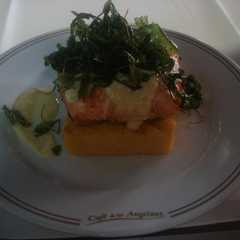Una foto de Taco de salmón al Chardonay sobre pave de polenta y rúcula frita
