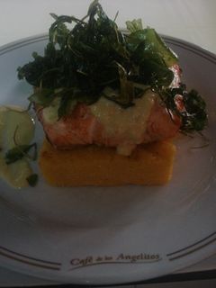 Una foto de Taco de salmón al Chardonay sobre pave de polenta y rúcula frita