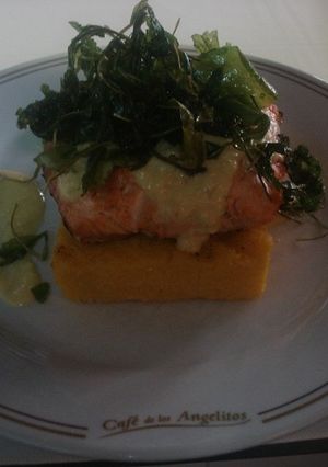 Una foto de Taco de salmón al Chardonay sobre pave de polenta y rúcula frita